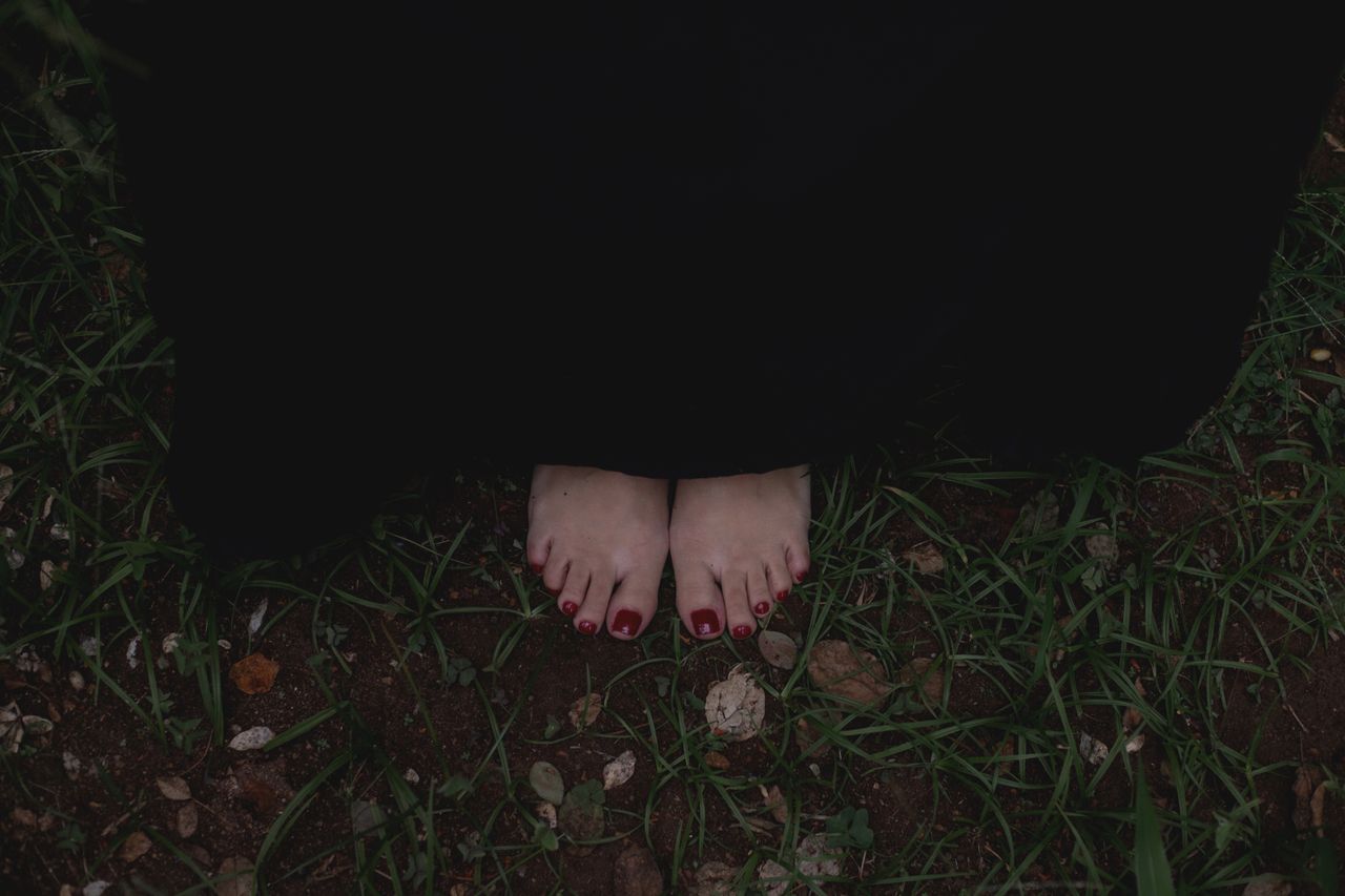 Effective Grounding Techniques for Stress and Anxiety Close-up of bare feet wrapped in a dark cloak standing on grass, evoking mystery.