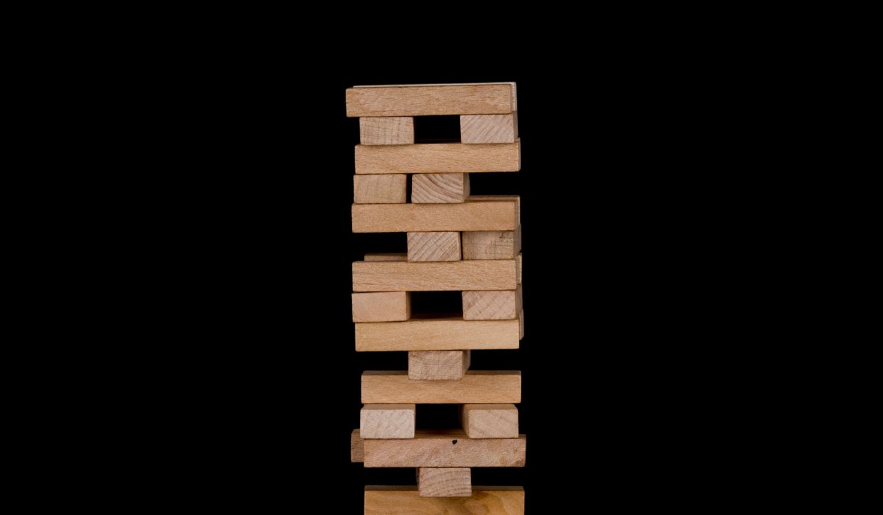 How to Build a Support System in Mental Health Recovery Close-up of wooden stacking blocks against a black backdrop.