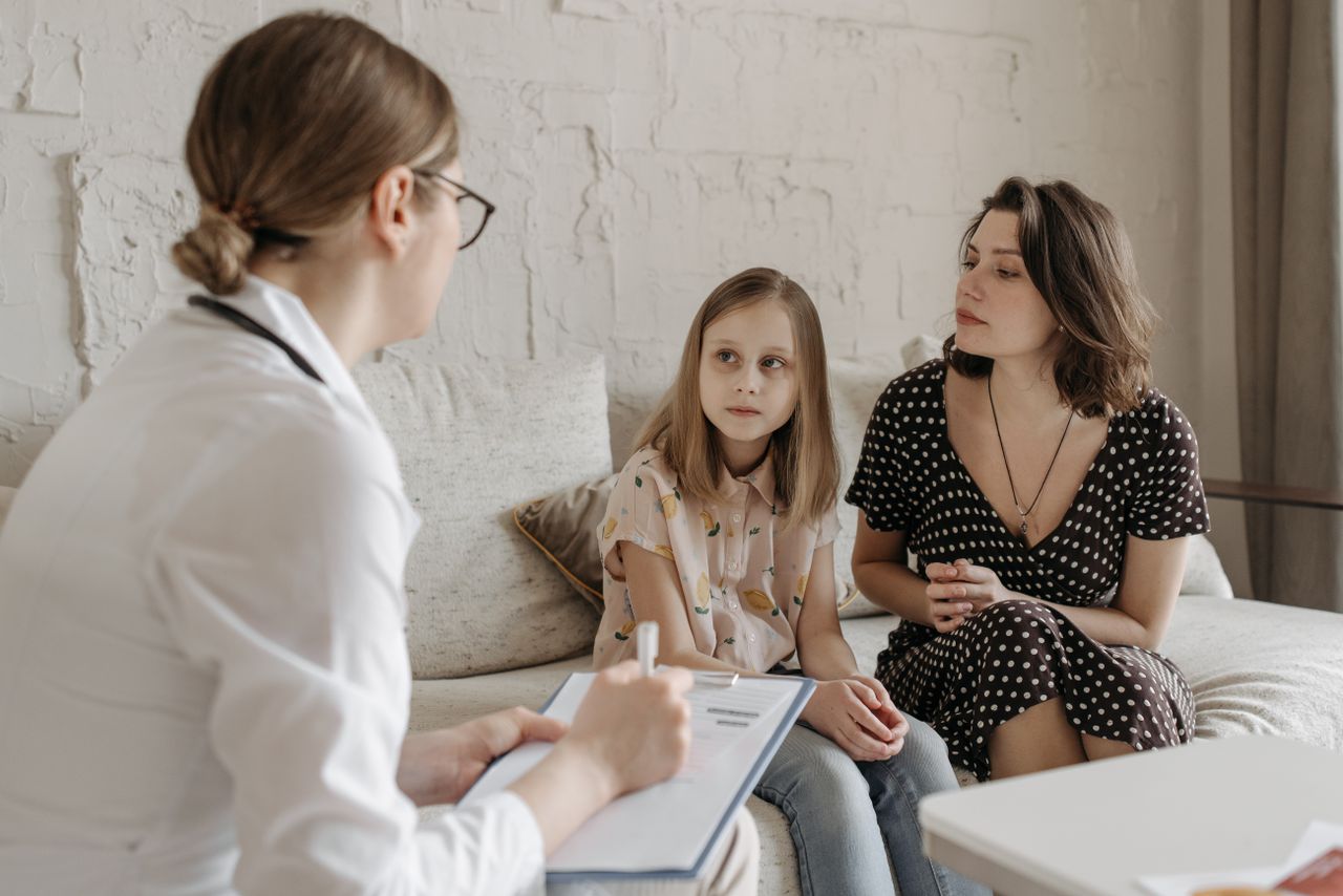 How to Choose a Mental Health Program Near You A mother and daughter consult with a doctor during a medical appointment indoors.